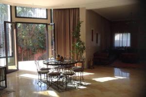 een eetkamer met een tafel en stoelen in een woonkamer bij Exceptionnel Villa 6 Rooms 12 guests Big Pool in Marrakesh