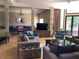 een woonkamer met banken en een flatscreen-tv bij Exceptionnel Villa 6 Rooms 12 guests Big Pool in Marrakesh