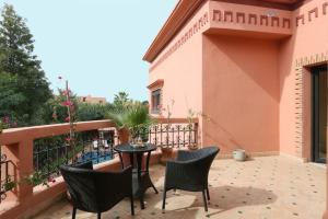 een patio met stoelen en een tafel op een balkon bij Exceptionnel Villa 6 Rooms 12 guests Big Pool in Marrakesh