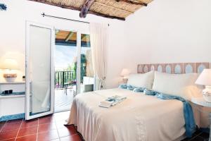 a bedroom with a bed and a balcony at Karamare in Stintino +30 photos