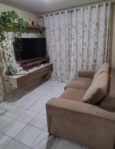 un soggiorno con divano e TV a schermo piatto di Residencial Viver Ananindeua ad Ananindeua