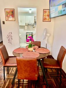 comedor con mesa y sillas y cocina en Pershing, depa bonito, 3camas wifi/cable, en Lima