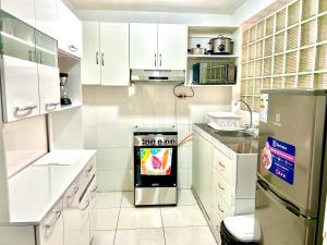a kitchen with white cabinets and a stainless steel stove at Pershing, depa bonito, 3camas wifi/cable in Lima