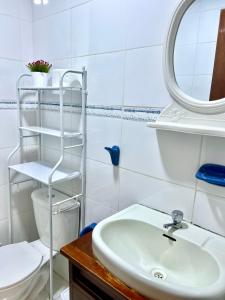 uma casa de banho com um lavatório, um WC e um espelho. em Pershing, depa bonito, 3camas wifi/cable em Lima