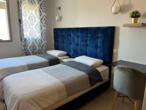 a bedroom with two beds and a blue headboard at Hadil Room in Rabat