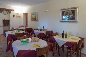 uma sala de jantar com mesas e cadeiras com toalha de mesa roxa em B&B Corte degli Struzzi em Pescia Romana