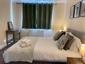 a bedroom with a bed with towels on it at Maidstone-Penenden House in Maidstone