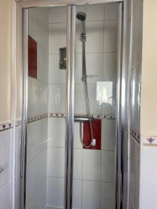 a shower with a hose in a bathroom at Maidstone-Penenden House in Maidstone