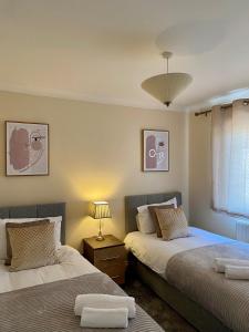 Duas camas sentadas uma ao lado da outra num quarto em Maidstone-Penenden House em Maidstone