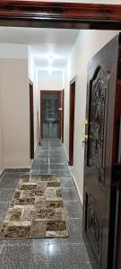 um corredor com uma porta e um piso de azulejo em Dakrour flat em ‘Izbat Ţanāţī