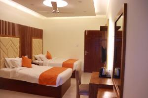 ein Hotelzimmer mit 2 Betten und einem Tisch in der Unterkunft Grand Castle Hotel & Resturant in Comilla