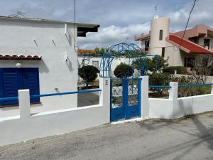 a white house with a blue door and a building at Blue and White in Kremasti
