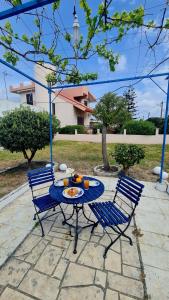 a blue table and chairs with a plate of food on it at Blue and White in Kremasti
