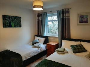 1 dormitorio con 2 camas y ventana en The Swansea View, en Skewen