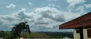 un ciel nuageux avec un palmier et un bâtiment dans l'établissement Kitnet Marília, à Marília