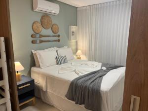 ein Schlafzimmer mit einem großen weißen Bett in einem Zimmer in der Unterkunft Flat aconchegante no Eco Resort Praia dos Carneiros - Cama Queen in Tamandaré