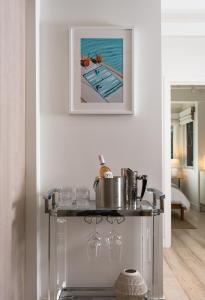 a table with wine glasses and a picture of a pool at Palm Cottage in Montecito