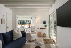 a living room with a blue couch and a bed at Palm Cottage in Montecito