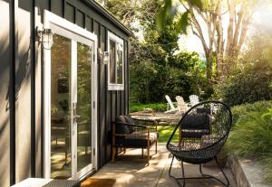 un patio con 2 sillas y una puerta de cristal en Palm Cottage, en Montecito