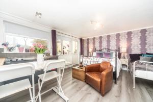 sala de estar con cama, mesa y sillas en 11 Boutique studio apartment perfect for peaceful getaway, secluded garden, quiet location, en High Wycombe