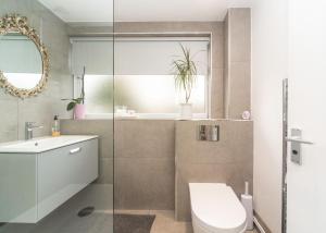 a bathroom with a toilet and a sink and a mirror at 11 Boutique studio apartment perfect for peaceful getaway, secluded garden, quiet location in High Wycombe