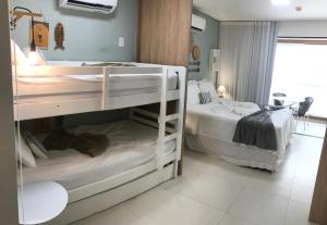 two bunk beds in a small room with a roomswersswersswersswers at Flat aconchegante no Eco Resort Praia dos Carneiros - Cama Queen in Praia dos Carneiros