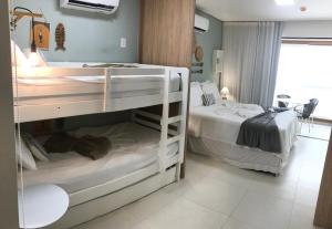 two bunk beds in a small room with a roomswersswersswersswers at Flat aconchegante no Eco Resort Praia dos Carneiros - Cama Queen in Tamandaré