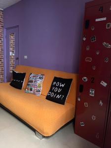 1 dormitorio con cama de color naranja y pared morada en DICI Coliving Housing The Friends Room, en Cabo San Lucas
