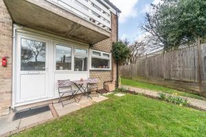 d'une terrasse avec une table et des chaises dans la cour. dans l'établissement 11 Boutique studio apartment perfect for peaceful getaway, secluded garden, quiet location, à High Wycombe