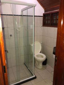 a bathroom with a toilet and a glass shower at Lindo chalé em Gravatá - Condomínio Mont Blanc V in Gravatá