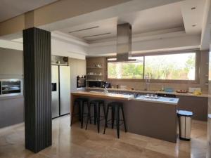 a kitchen with a large island with bar stools at Villa de rêve à Marrakech in Marrakech