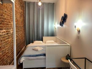 Habitación pequeña con cama y pared de ladrillo en Brand new CAMELIA ROOM with private bathroom, en Bruselas