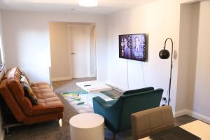 ein Wohnzimmer mit einem Sofa und einem Stuhl in der Unterkunft Garland Modern Apartment with Private Garden & Parking Dartford 5 in Kent