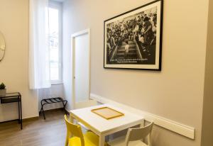 uma sala de jantar com mesa e cadeiras e uma imagem na parede em A CASA DI PUPA GUEST HOUSE em Nápoles