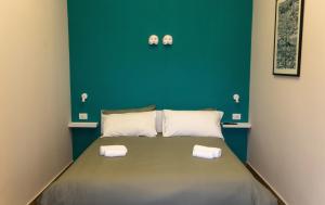 uma cama num quarto com uma parede verde em A CASA DI PUPA GUEST HOUSE em Nápoles