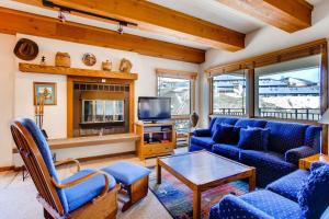 a living room with blue couches and a tv at Large 2 Br With Open Floorplan Condo in Crested Butte