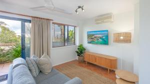 a living room with a couch and a window at Coast Yamba - Adults Only in Yamba