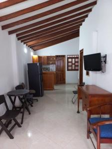 a living room with a table and chairs and a tv at Apartamentos con estacionamiento cerca al parque in Támesis