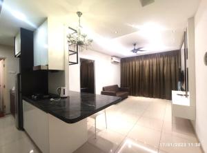 uma cozinha e sala de estar com um balcão preto em Shah Suites Vista Alam em Shah Alam