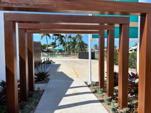 un arco de madera que conduce a una piscina en un complejo en Galaxy Mackay Motor Inn, en Mackay