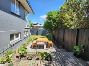 a backyard with a wooden table and a fence at Beautifully renovated townhouse, easy walk to CBD in Blenheim