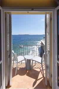 a balcony with a table and chairs and the ocean at Hotel Hermes in Ermoupoli