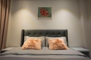 Duas almofadas peludas numa cama num quarto em Vila Perla Gjiri Lalzit , Perla Resort em Durrës