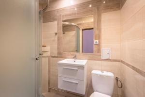 a bathroom with a toilet and a sink and a mirror at 70s Hostel in Krakow