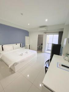 - une chambre avec un lit blanc et un bureau dans l'établissement SC Residences, à Surat Thani