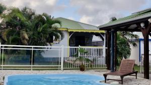 a house with a swimming pool and a chair at Domaine de Portland in Le Moule