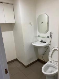 een witte badkamer met een toilet en een wastafel bij Stay in my awesome home while in Cagayan de Oro City in Cagayan de Oro