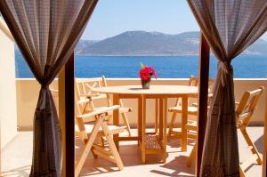 a table with a vase of flowers on a balcony at Lycia Hotel in Kaş