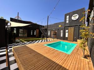 - une piscine sur une terrasse en bois devant un bâtiment dans l'établissement Miel House Villa Alemana Beehouse, à Villa Alemana