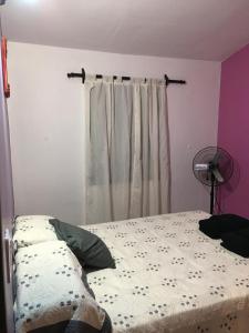 1 dormitorio con 1 cama, ventilador y ventana en La Casa de Minona en Salta